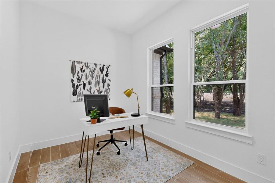 Bright room with wood-finish flooring and multiple windows, providing ample natural light