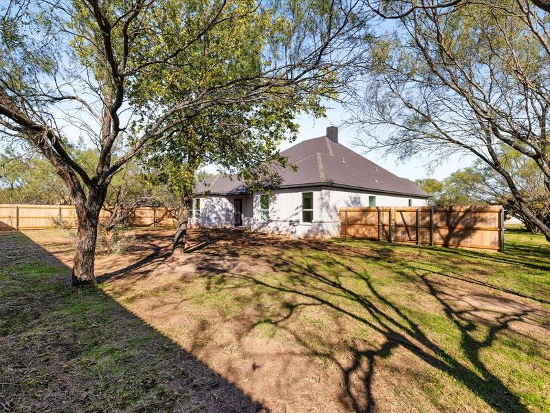 Back of property featuring a fenced backyard and a chimney