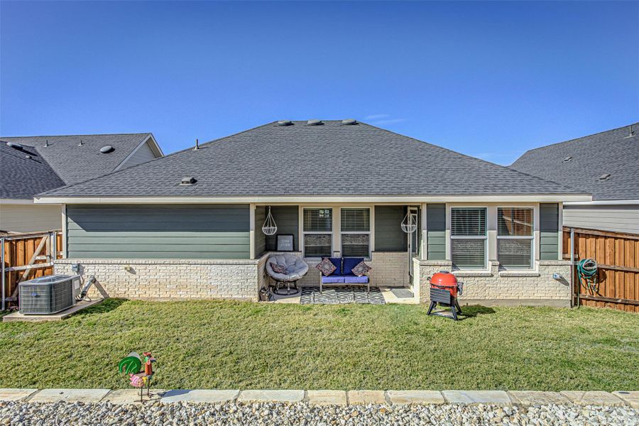 Back of property featuring a fenced backyard, a patio, and roof with shingles
