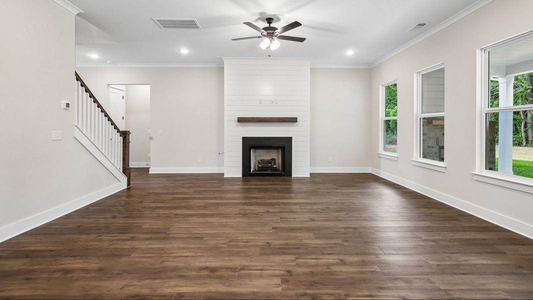 Gathering room with ceiling fan, fireplace, and hard surface flooring Gathering room with ceiling fan, fireplace, and hard surface flooring
