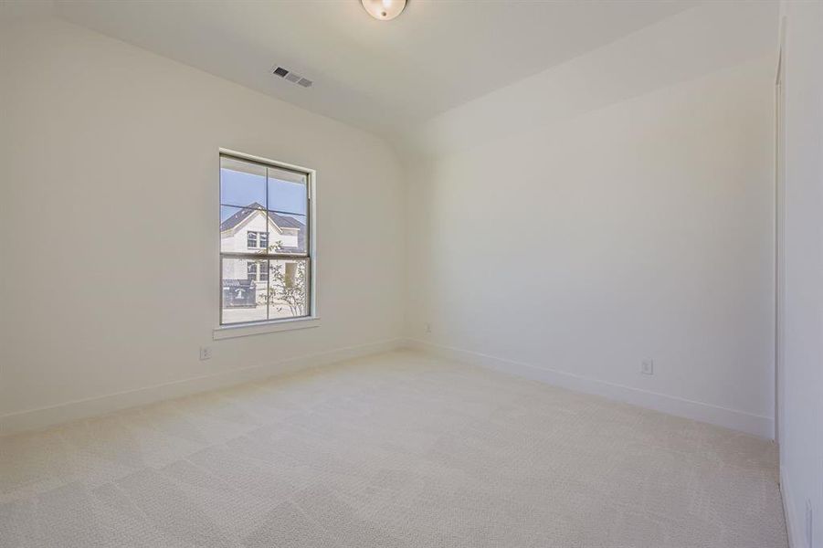 Spare room with light colored carpet and vaulted ceiling Spare room with light colored carpet and vaulted ceiling