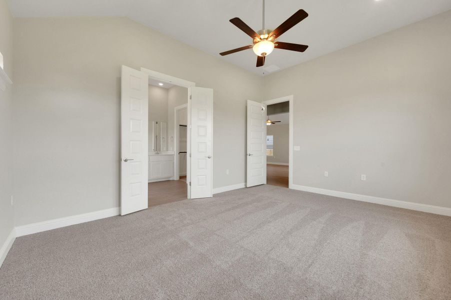 Unfurnished bedroom featuring carpet flooring, ensuite bathroom, a ceiling fan, and lofted ceiling Unfurnished bedroom featuring carpet flooring, ensuite bathroom, a ceiling fan, and lofted ceiling