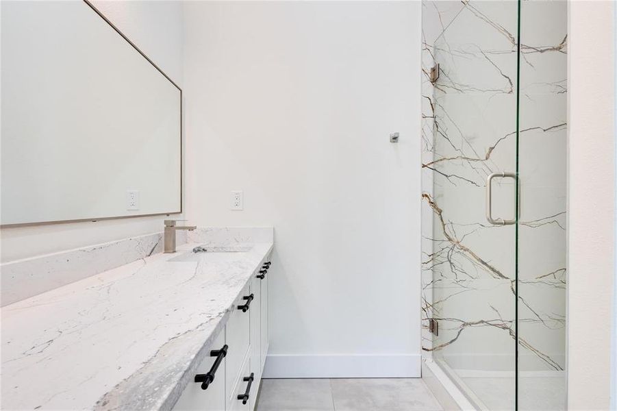 Bathroom with tile patterned floors, vanity, and an enclosed shower