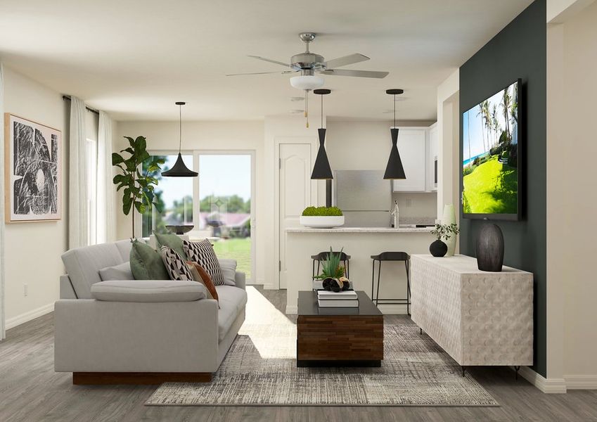 Rendering of a living room furnished with a grey couch across from a TV on the wall. The kitchen can be seen next to the living room. Rendering of a living room furnished with a grey couch across from a TV on the wall. The kitchen can be seen next to the living room.