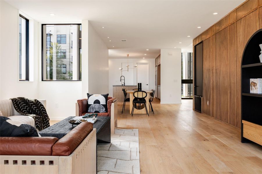 Living area featuring light wood finished floors, recessed lighting, and expansive windows