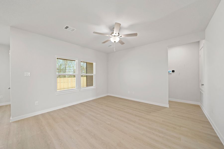 A room with a ceiling fan and a wood floor. A room with a ceiling fan and a wood floor.