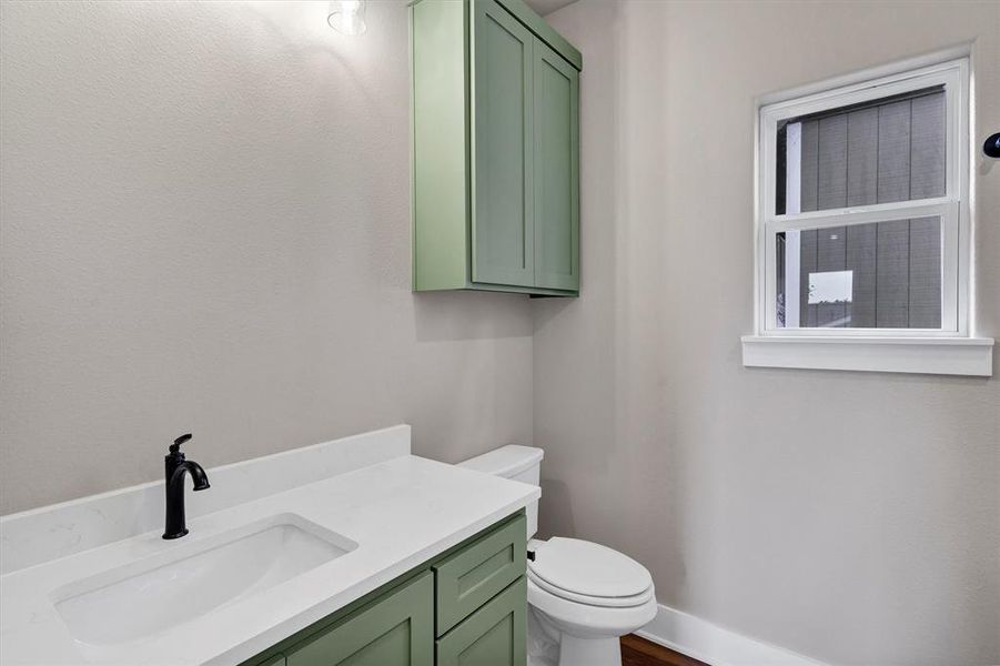 Half bathroom with vanity and toilet