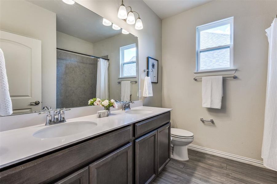 Full bathroom downstairs with dual sinks and storage closet. Full bathroom downstairs with dual sinks and storage closet.