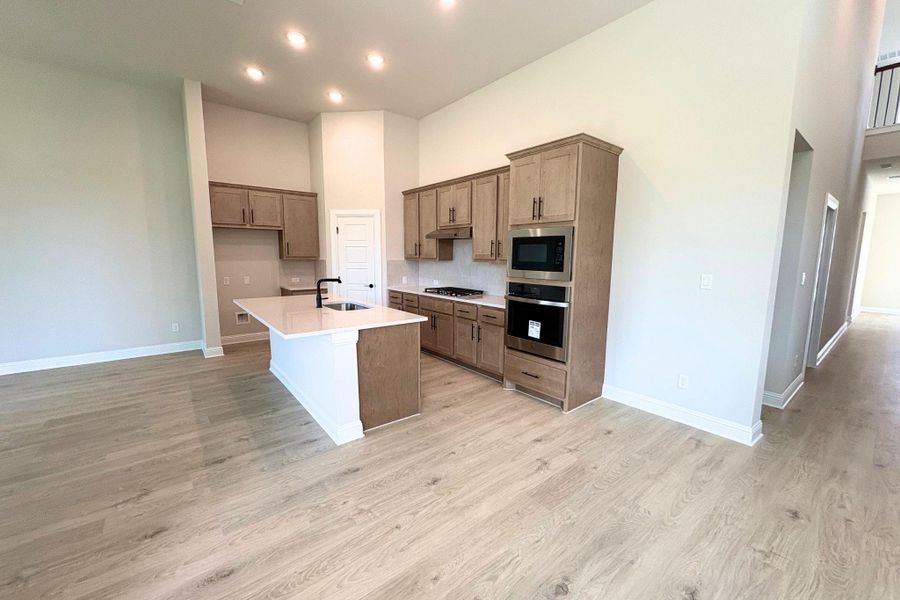 A well-lit kitchen with sleek appliances and ample counter space for culinary creations. A well-lit kitchen with sleek appliances and ample counter space for culinary creations.