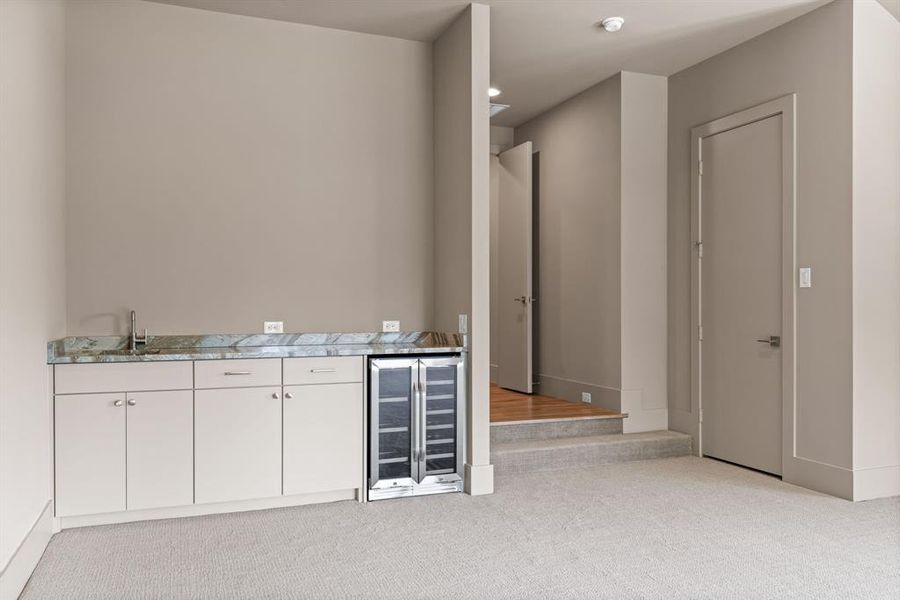 Indoor wet bar with beverage cooler and carpet flooring Indoor wet bar with beverage cooler and carpet flooring