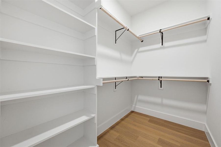 Primary Walk-In Closet features built-in shelving designed for organization and storage. Multiple
hanging rods extend throughout the space. Vinyl flooring extends throughout.