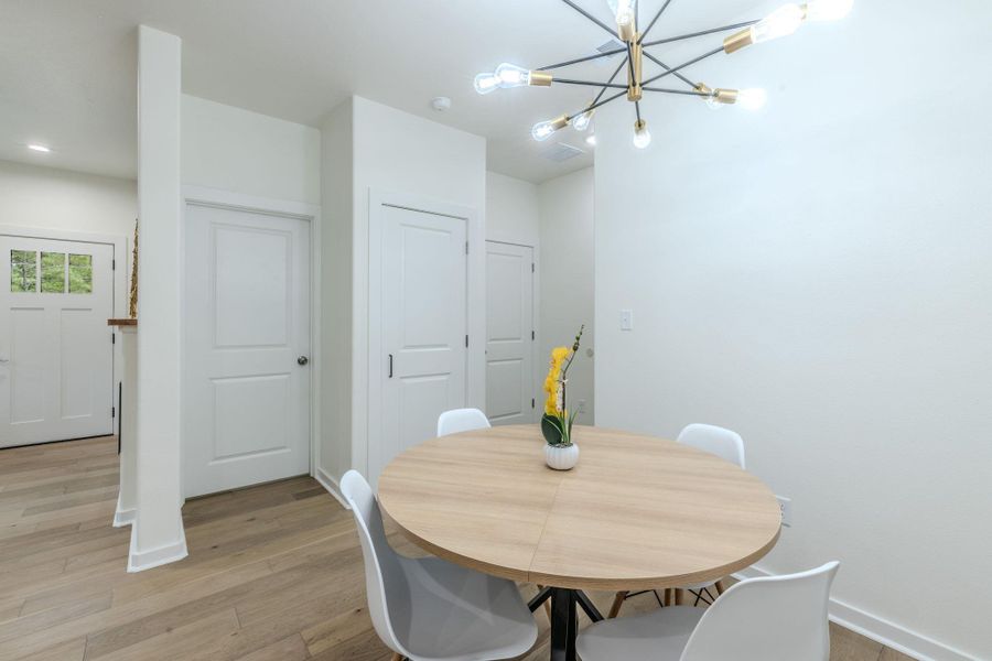An inviting dining area offers warm wood flooring and an appealing modern light fixture. An inviting dining area offers warm wood flooring and an appealing modern light fixture.