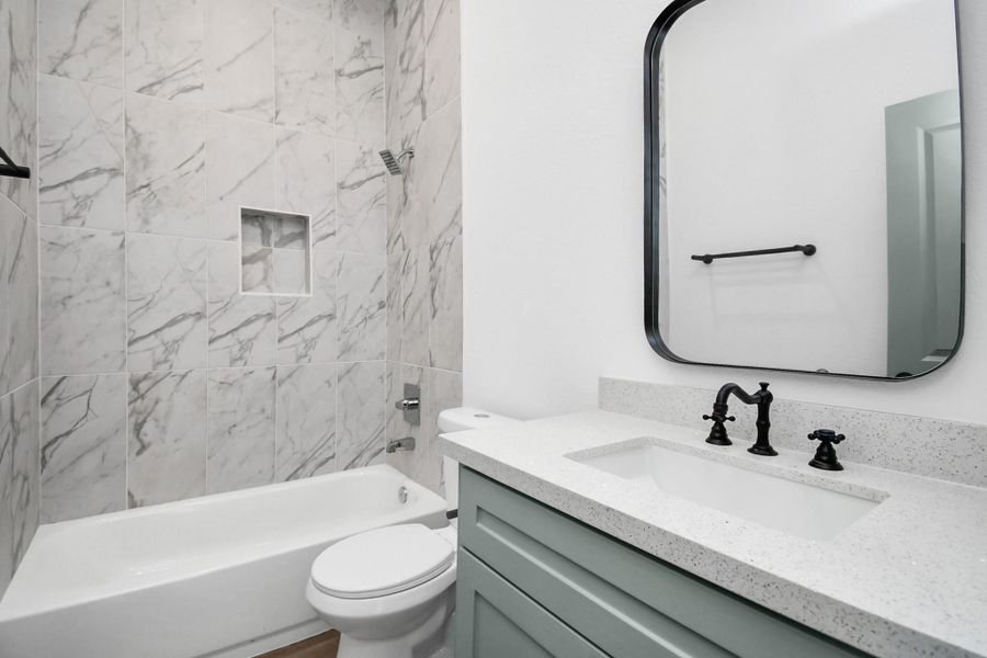 Full bath in the hallway with gorgeous and neutral finishes.