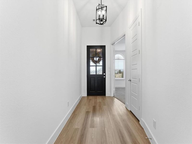 Foyer entrance featuring a chandelier and light wood-type flooring