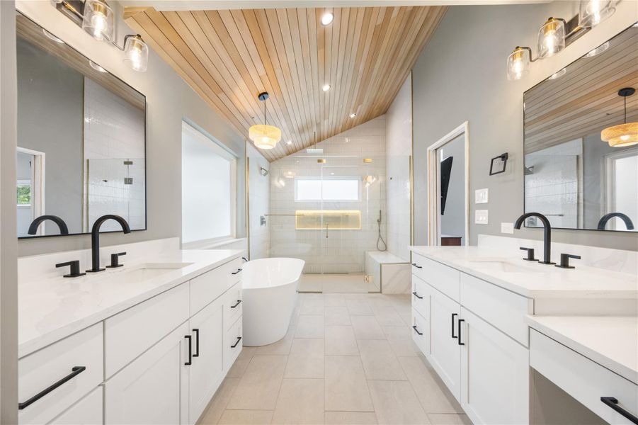 Full bath with a vaulted wooden ceiling, a freestanding tub, two vanities, a shower stall, and recessed lighting