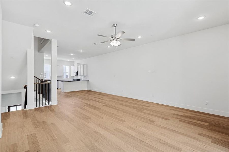 Unfurnished living room with light hardwood / wood-style flooring and ceiling fan Unfurnished living room with light hardwood / wood-style flooring and ceiling fan