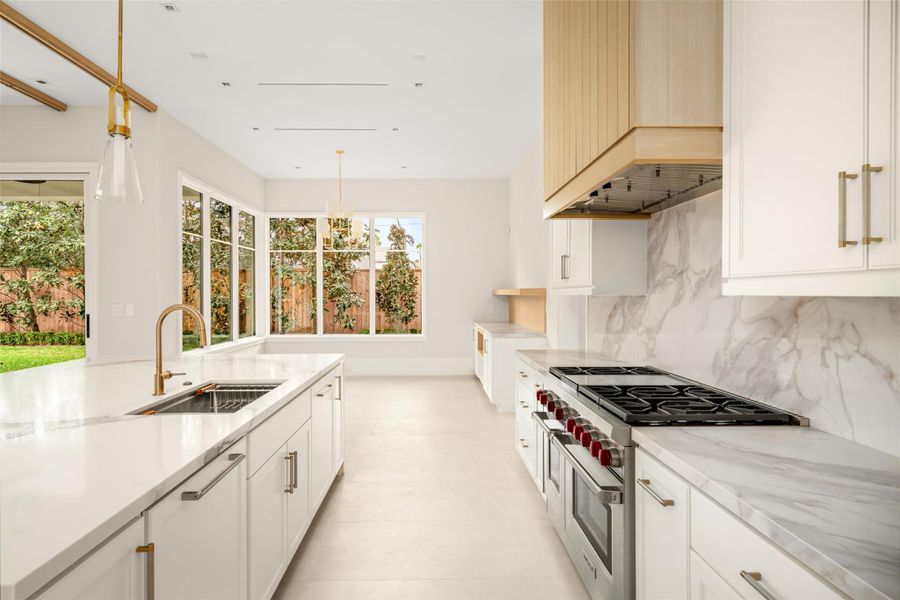 A seamless transition from the kitchen to a bright breakfast area, surrounded by windows and garden views.