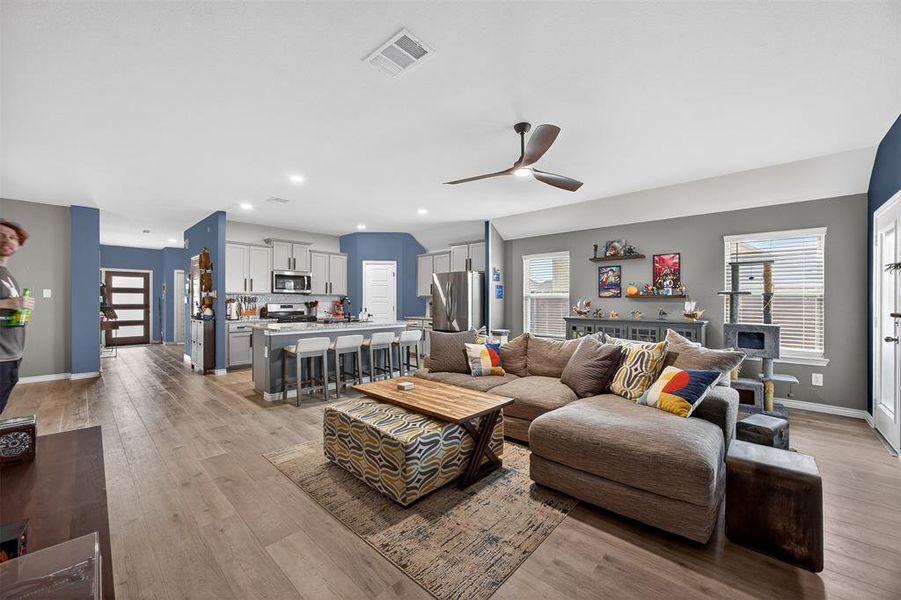 Living room with light wood-type flooring, ceiling fan, healthy amount of natural light, and recessed lighting
