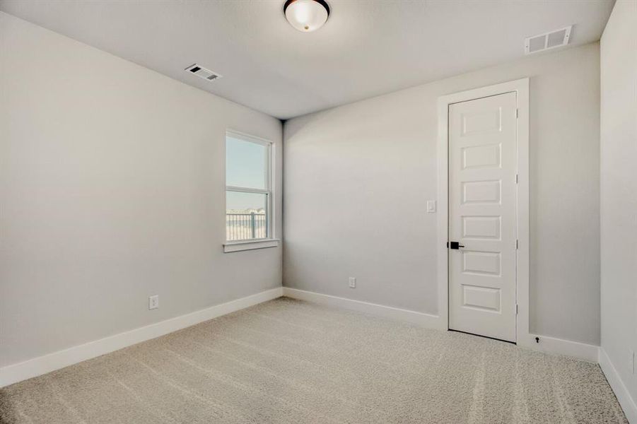 Spare room with light colored carpet and baseboards