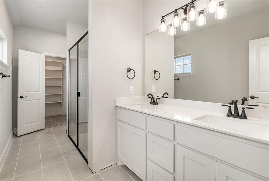 Bathroom featuring walk in shower, tile patterned flooring, and dual bowl vanity