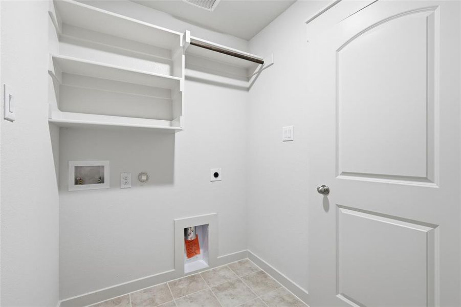 Laundry area with washer hookup, hookup for a gas dryer, hookup for an electric dryer, and light tile patterned floors Laundry area with washer hookup, hookup for a gas dryer, hookup for an electric dryer, and light tile patterned floors