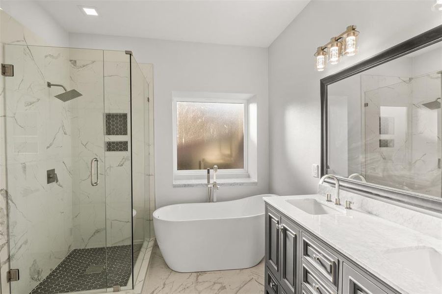Full bathroom featuring a marble finish shower, a soaking tub, light marble finish flooring, and double vanity