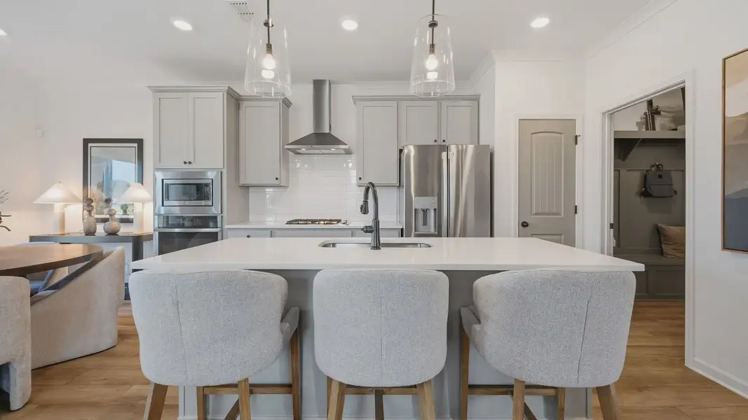 Spacious kitchen with center island and stylish cabinetry in Langley Overlook new construction townhome in Loganville, GA.