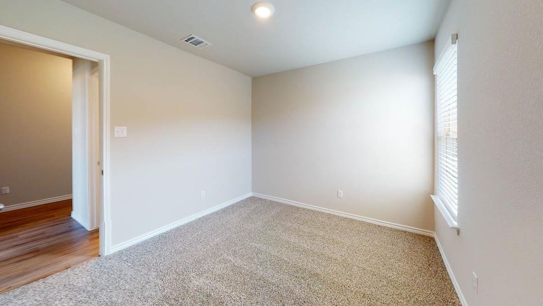 Spare room featuring light carpet and baseboards