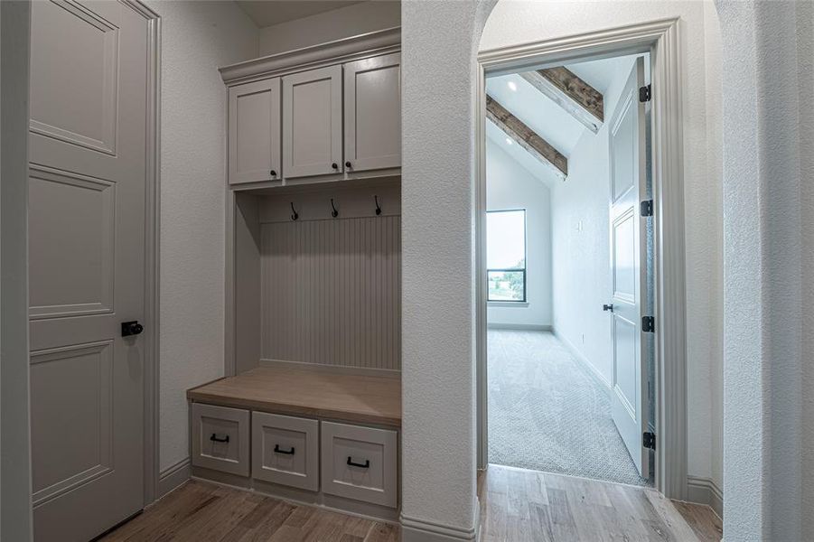 Mudroom featuring light wood finished floors and a textured wall Mudroom featuring light wood finished floors and a textured wall