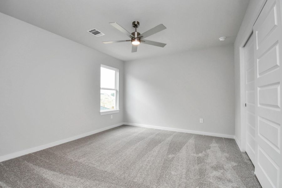 Secondary bedroom features plush carpeting, large windows that let in plenty of natural light, bright paint, and spacious closets. Sample photo of completed home with similar floor plan. Actual colors and selections may vary. Secondary bedroom features plush carpeting, large windows that let in plenty of natural light, bright paint, and spacious closets. Sample photo of completed home with similar floor plan. Actual colors and selections may vary.