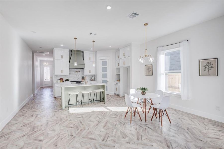 Dining room with light parquet flooring and a healthy amount of sunlight