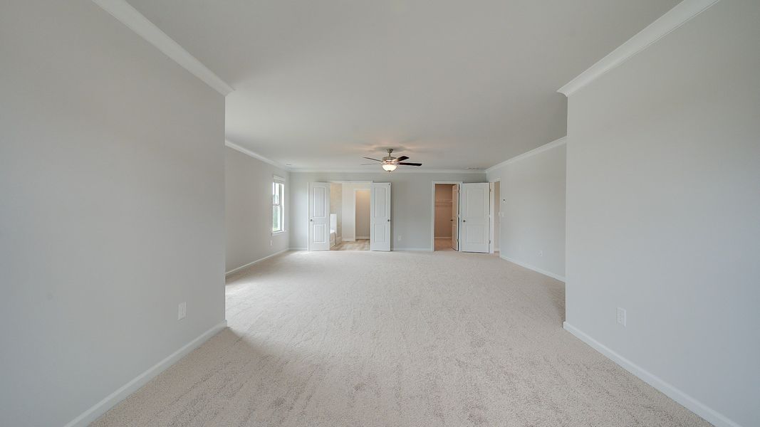 Meridian II primary suite sitting room with carpet flooring and spacious layout at Brighton in Locust Grove, GA.