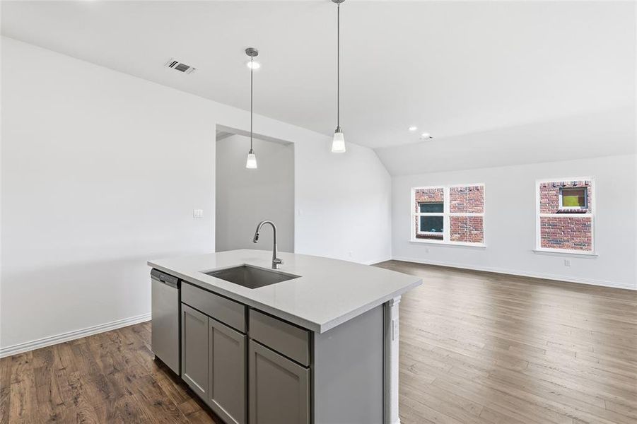 Kitchen island featuring a stainless steel sink, gooseneck faucet, and integrated dishwasher
