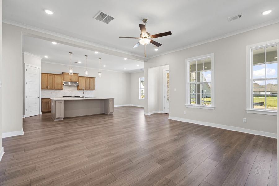 Unfurnished living room featuring crown molding, ceiling fan, recessed lighting