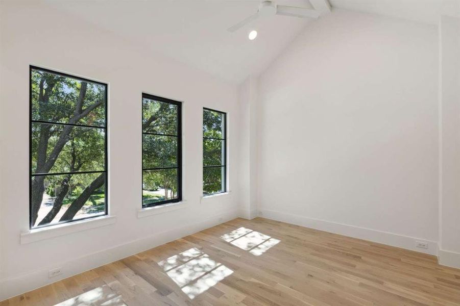 Spare room with vaulted ceiling with beams, ceiling fan, and light hardwood / wood-style flooring