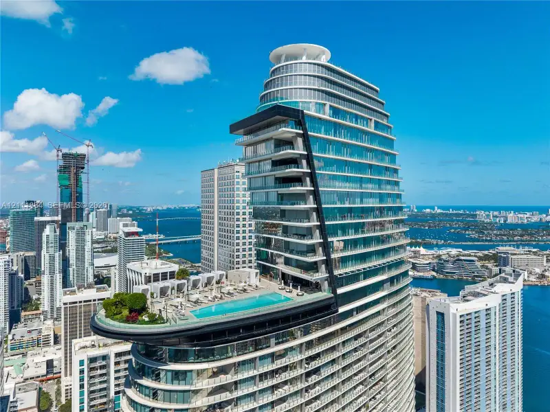 High-rise structure featuring floor-to-ceiling glass paneling, cantilevered balconies, a rooftop pool, and extensive exterior deck space High-rise structure featuring floor-to-ceiling glass paneling, cantilevered balconies, a rooftop pool, and extensive exterior deck space
