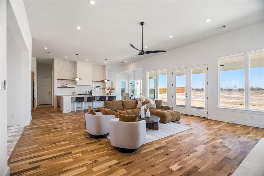 Living room with french doors and light hardwood / wood-style floors