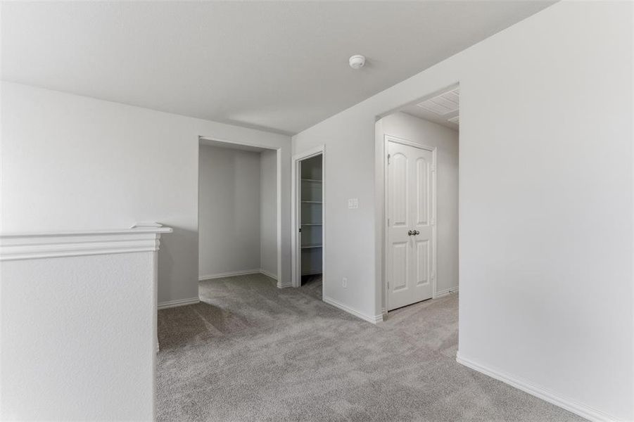 Empty room featuring light colored carpet and baseboards