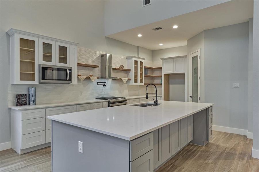 This modern kitchen has floating shelves, Quartz countertops, and soft close cabinets and drawers. The cabinets under the bar area also open up for additional storage!