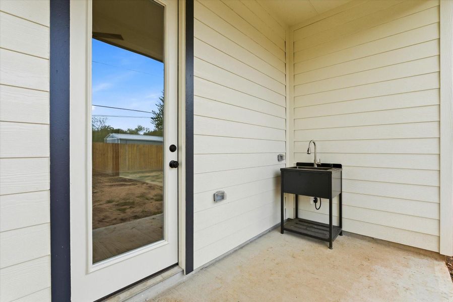 The covered patio features a convenient utility sink, ideal for washing pets, rinsing outdoor gear, or handling quick clean-ups. The covered patio features a convenient utility sink, ideal for washing pets, rinsing outdoor gear, or handling quick clean-ups.