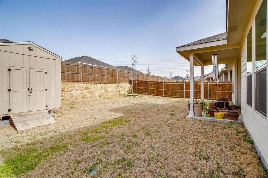 View of yard featuring an outbuilding, a fenced backyard, and a storage unit