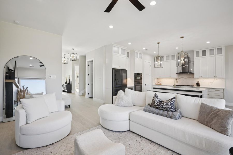 Living area featuring hanging lights, light wood-type flooring, and ceiling fan