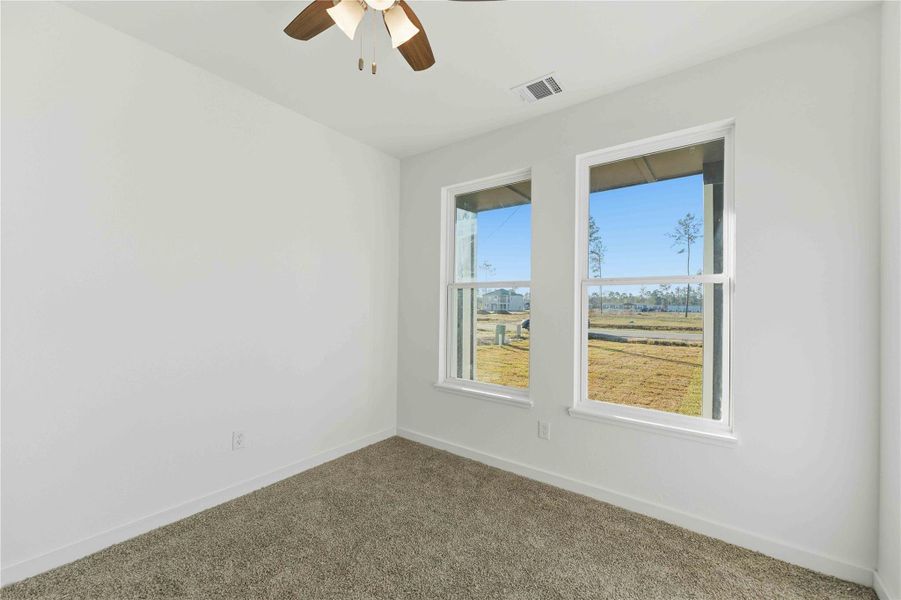 Versatile first floor room ideal for a home office, study, or guest bedroom. Bright and inviting with large windows, plush carpeting, and a ceiling fan, this flexible space adapts perfectly to your lifestyle whether for work, learning, or rest
