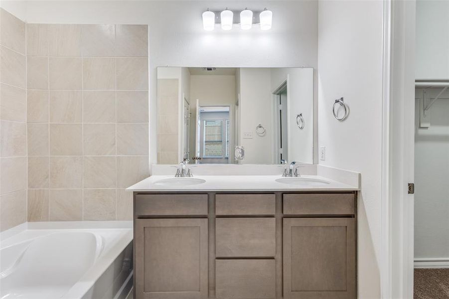 Bathroom with double vanity, a bath, and a walk in closet Bathroom with double vanity, a bath, and a walk in closet