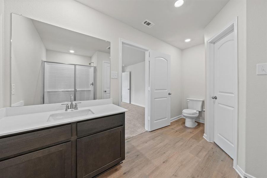 Bathroom with vanity, toilet, and hardwood / wood-style floors