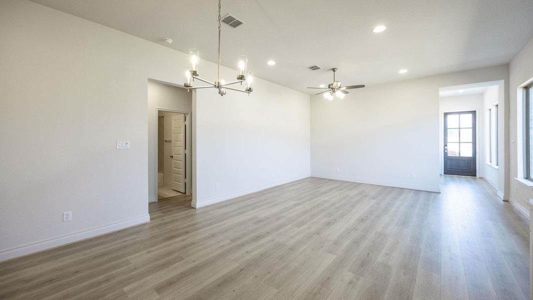Spare room with a chandelier, baseboards, light wood-style flooring, recessed lighting, and a ceiling fan Spare room with a chandelier, baseboards, light wood-style flooring, recessed lighting, and a ceiling fan