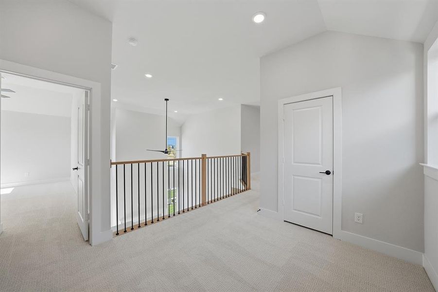 Corridor with light colored carpet and recessed lighting