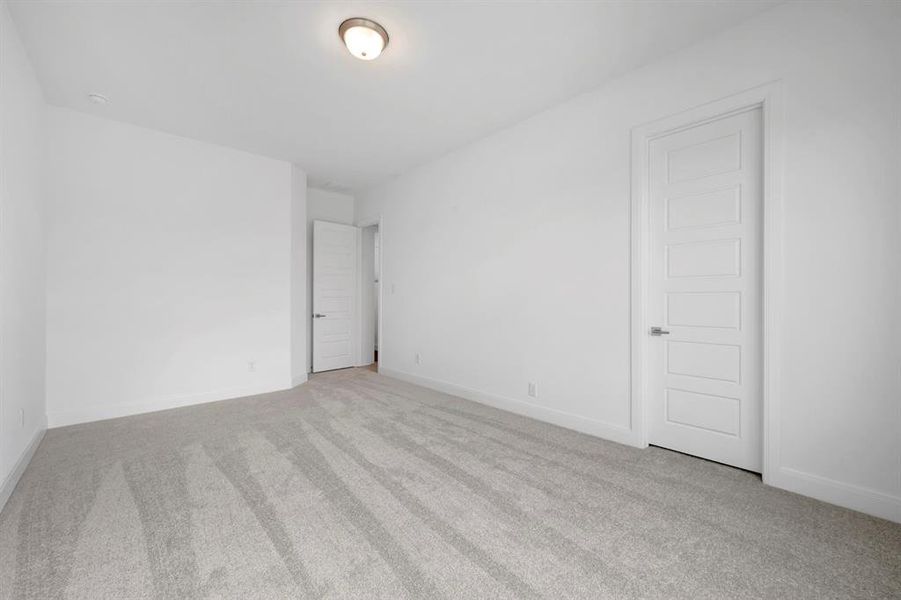 Spare room featuring light colored carpet and baseboards Spare room featuring light colored carpet and baseboards
