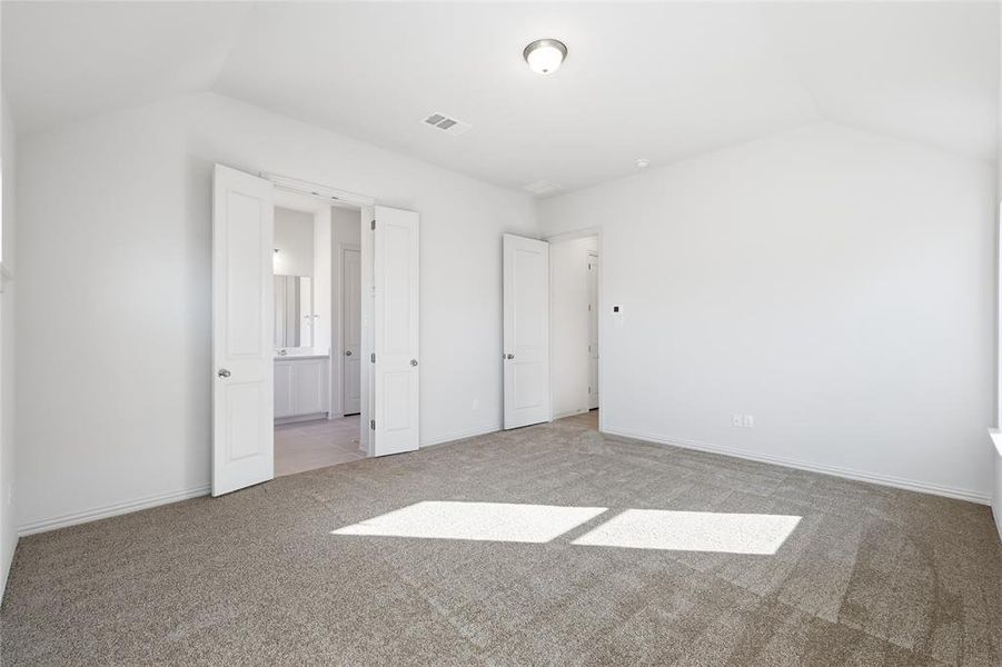 Unfurnished bedroom featuring vaulted ceiling and light colored carpet Unfurnished bedroom featuring vaulted ceiling and light colored carpet