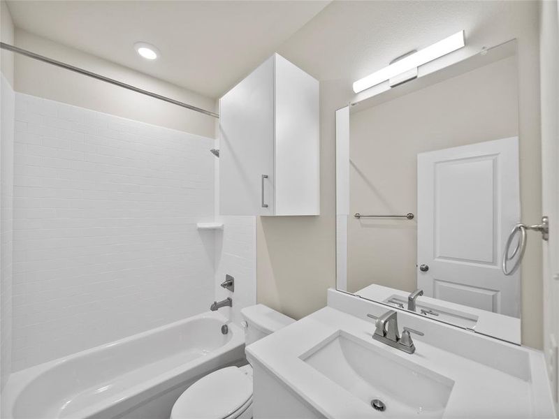 Bathroom featuring  shower combination, vanity, and toilet